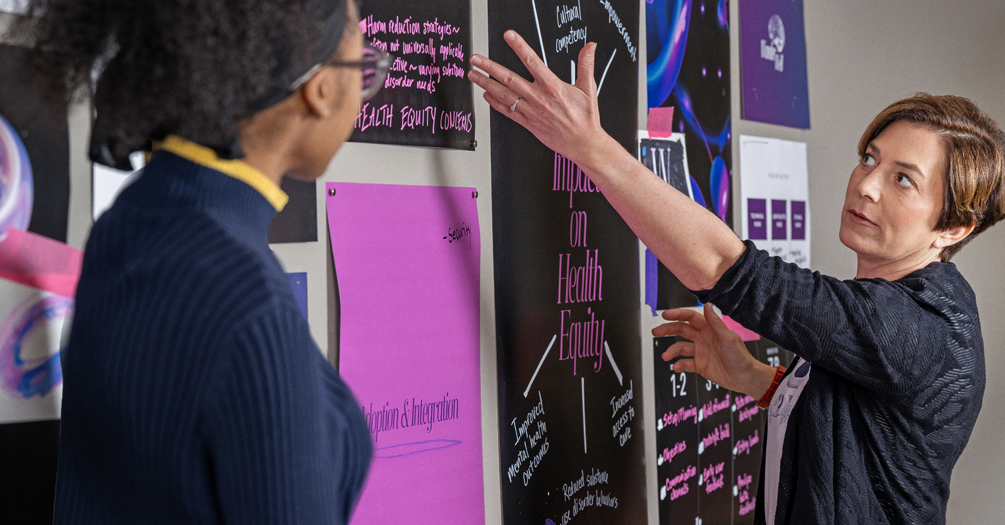 Zhariyah Laughlin, left, watches as Frederique Laubepin shows the class what to do on the whiteboard