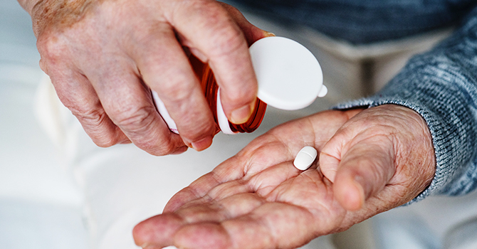 older adult taking pill