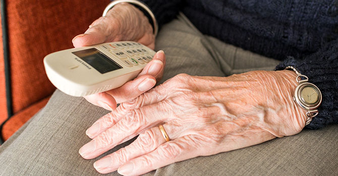 Elderly man holding a cordless telephone