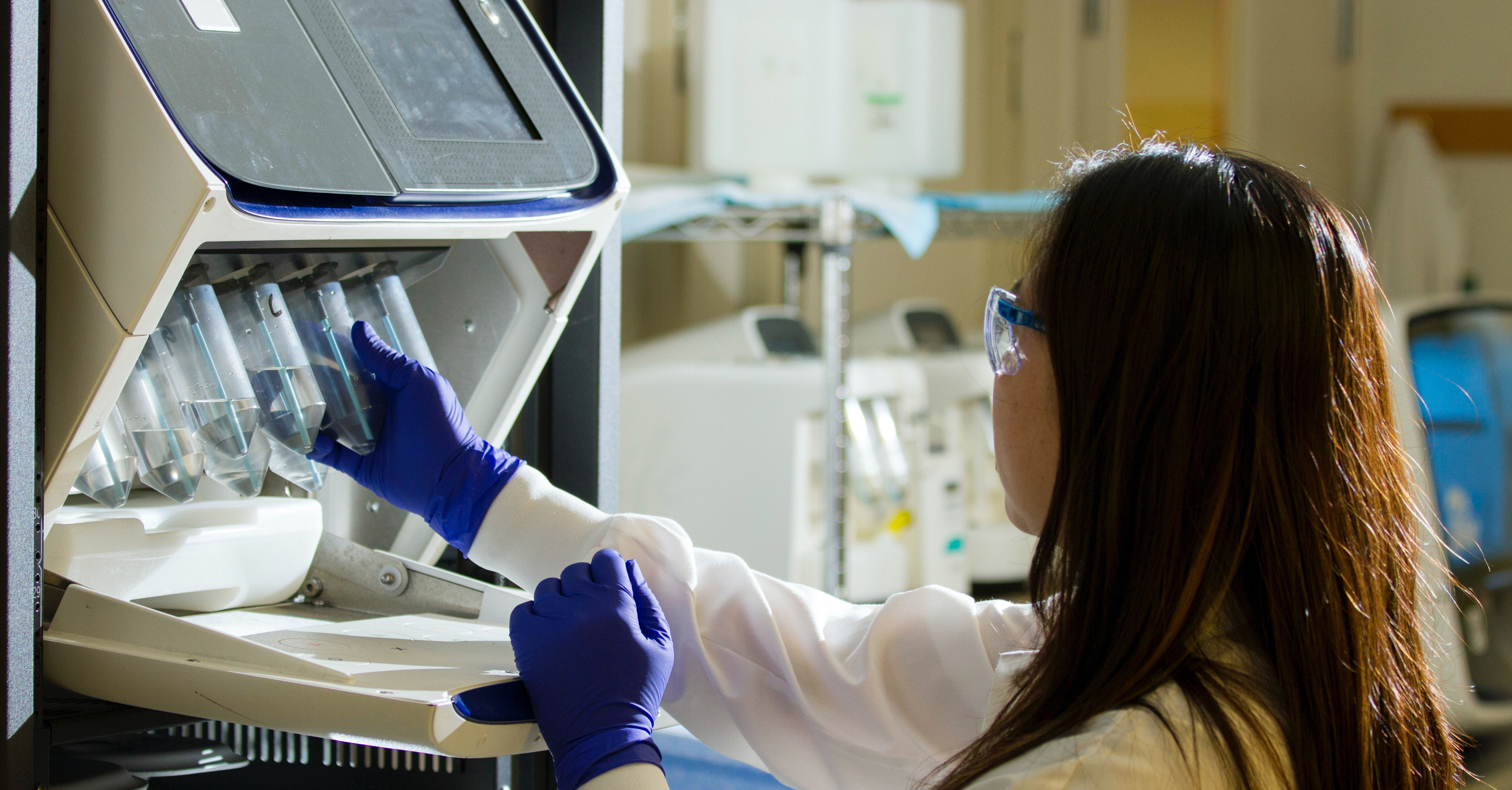 A woman works in a lab conducting DNA genotyping and sequencing.