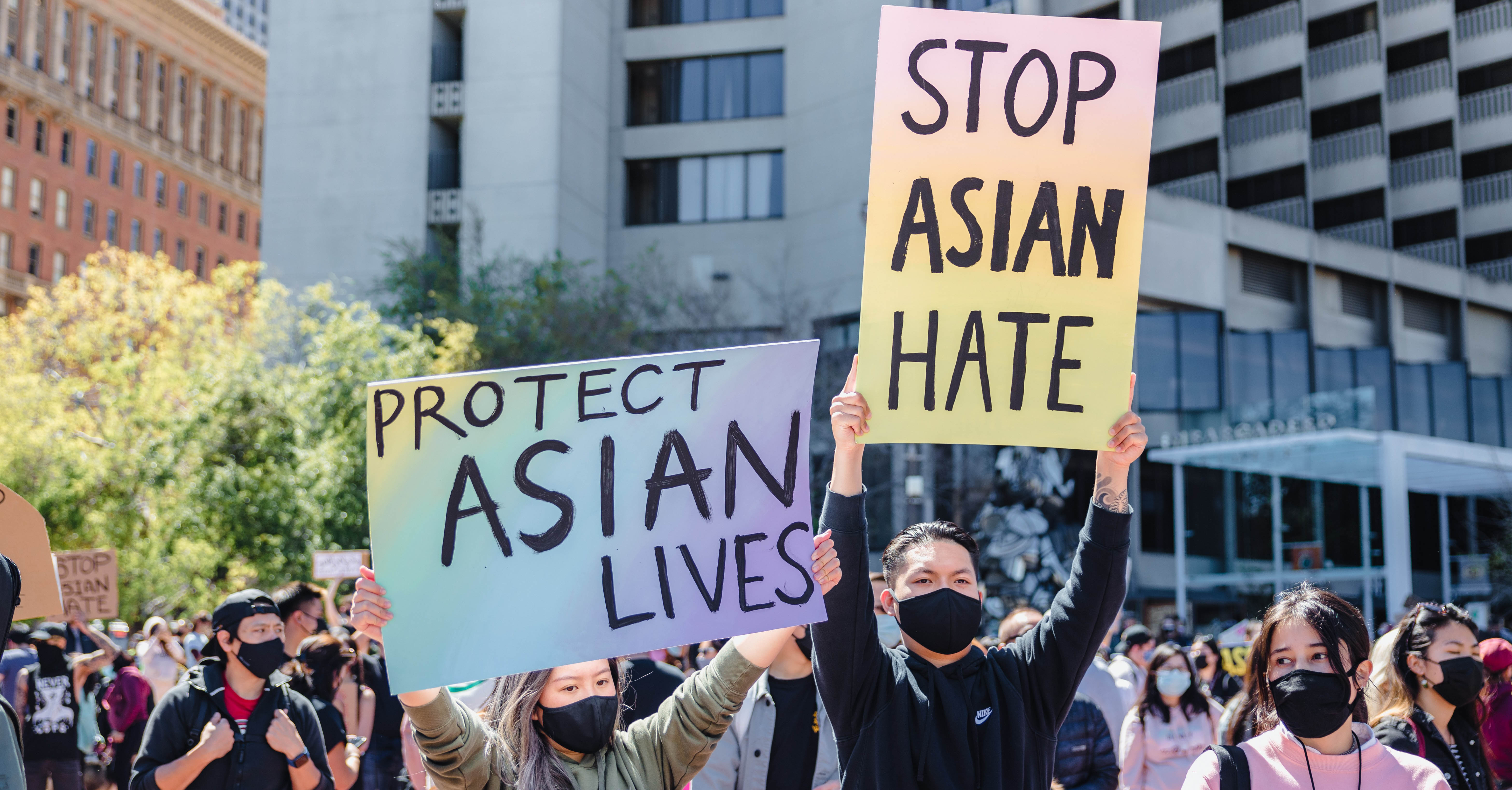 People stand outside with signs that say 