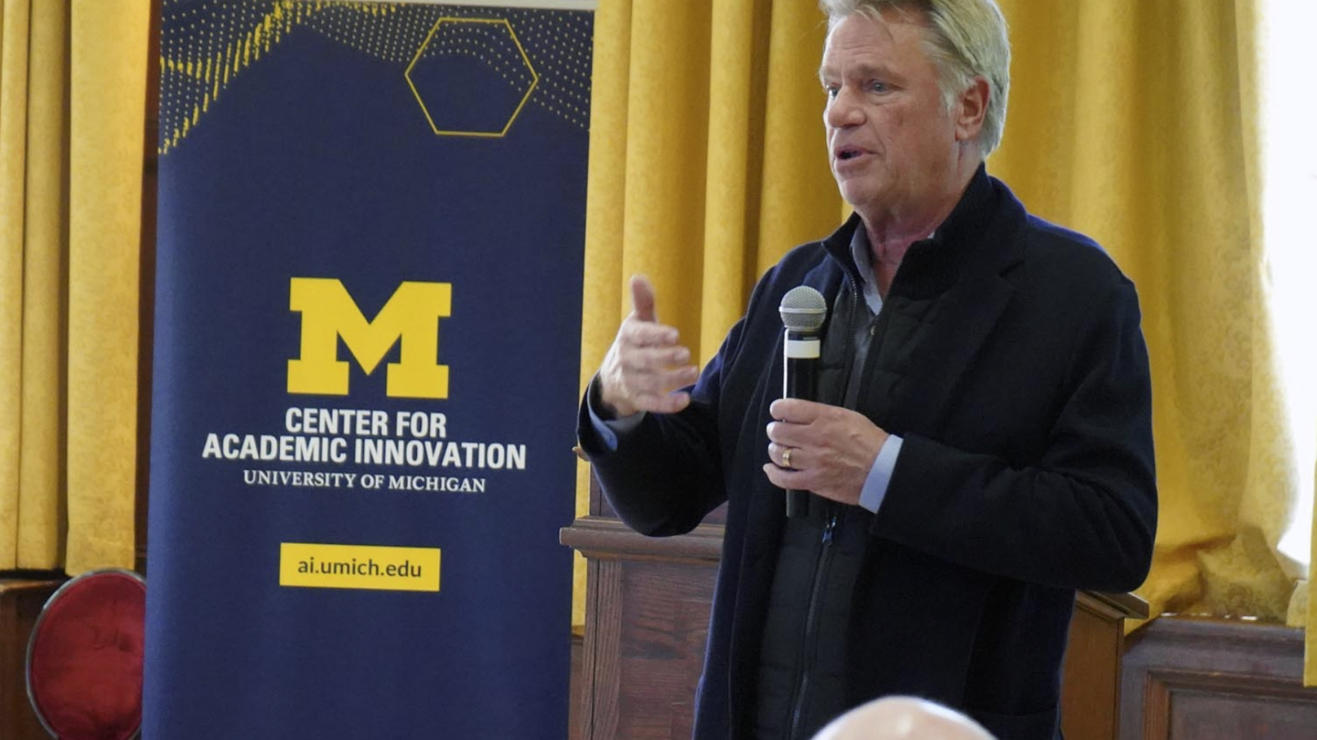 Vic Stretcher speaking in front of a U-M Center for Academic Innovation banner.