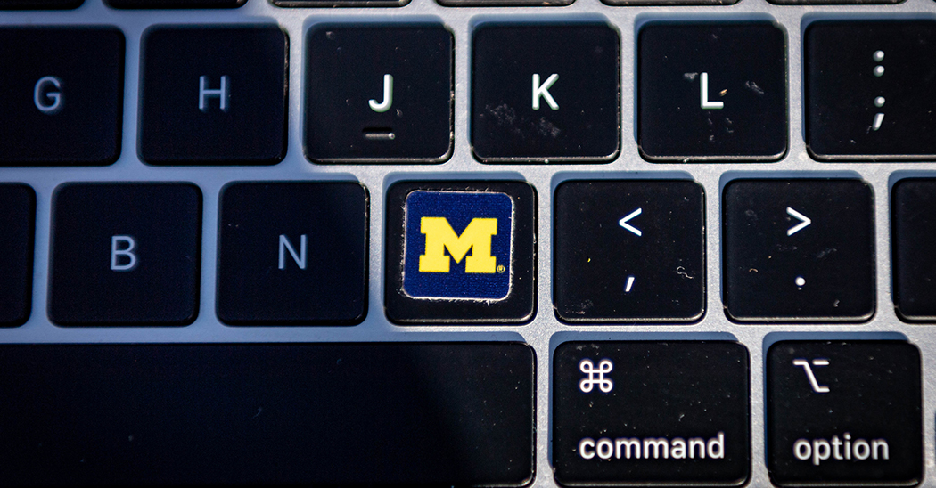 An image of a keyboard, showing G, H, J, K L, semicolon/colon , B, N, M, comma/left arrow, period/right arrow, part of the space bar, command key and the option key. A blue and yellow block M is on the M key.
