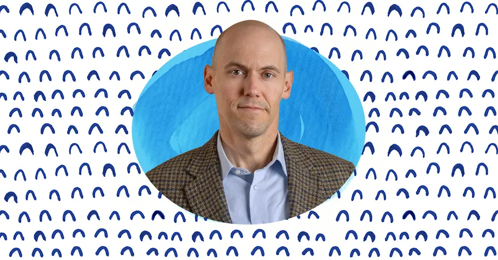 Justin Heinze headshot, framed within an light blue oval on a white and blue patterned background.