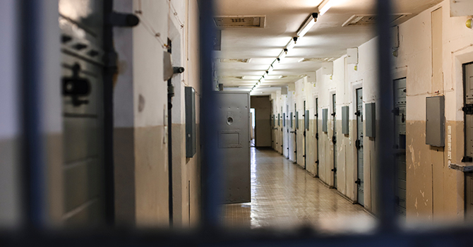 the interior of a prison block seen through prison bars