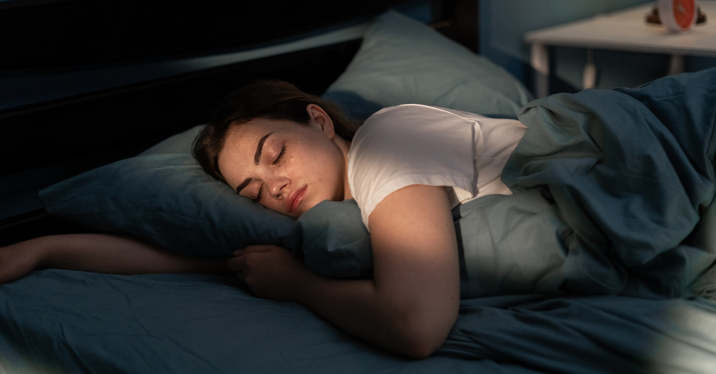 A woman sleeps in her bedroom.